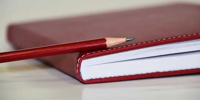 赤いカバーのノートと鉛筆